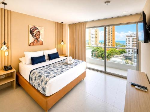 a bedroom with a large bed and a large window at Vadamar Hotel Collection Rodadero in Gaira