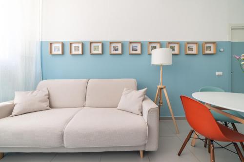 a living room with a white couch and a table at Maréa apartments - Sul mare 2 in Alba Adriatica