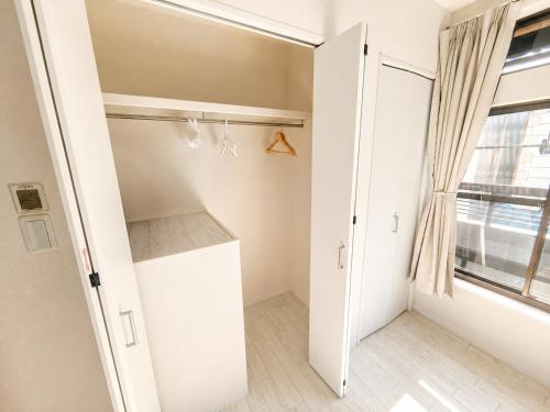 a small room with a closet and a window at New Entire Family House 1 Min to Metro Umeda Direct in Osaka