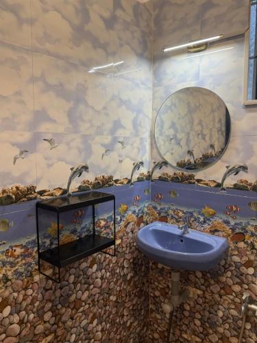 a bathroom with a sink and a painting on the wall at Daffodil in Anjuna