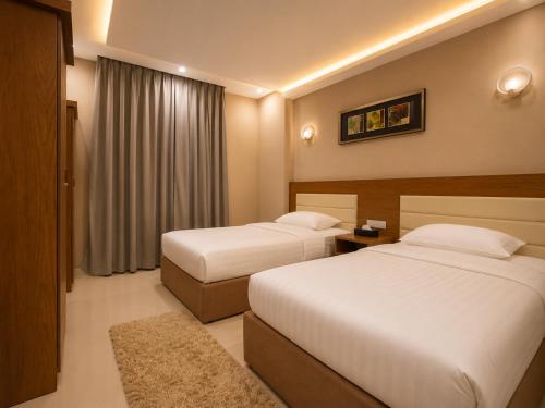 a hotel room with two beds and a window at Elsafa Hotel in Salalah