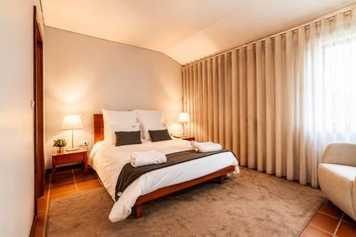 a bedroom with a large bed and a window at Quinta da Eira do Sol in Guimarães
