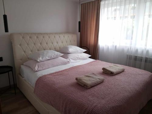 a bedroom with a bed with two towels on it at Panorama Pienin- apartamenty i studio in Sromowce Wyżne