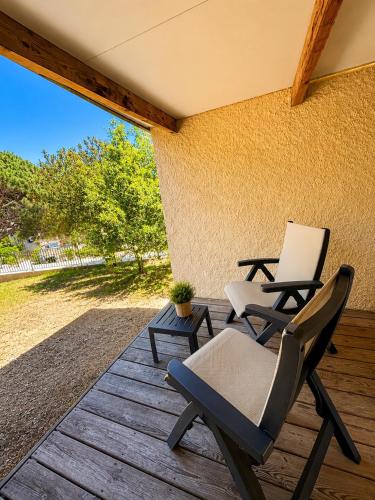 two chairs sitting on a wooden deck at Charmant studio avec terrasse in Fréjus