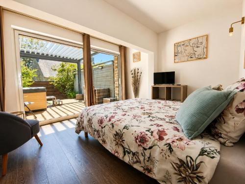 a bedroom with a bed and a sliding glass door at Aux Matins du Bonheur in Surzur