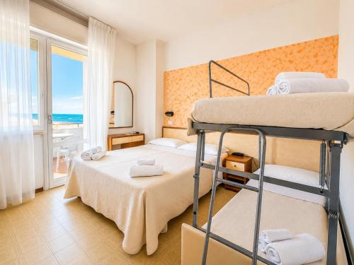 a bedroom with two bunk beds and a balcony at Hotel TYC in Rimini