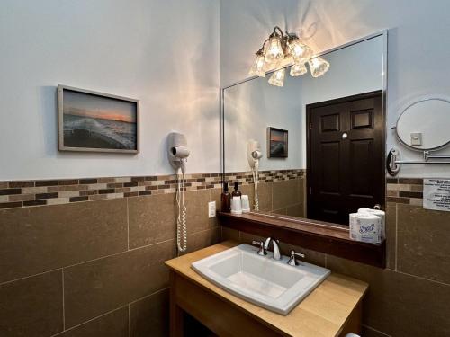 a bathroom with a sink and a mirror at Auberge Du Lac Malcom in Sayabec