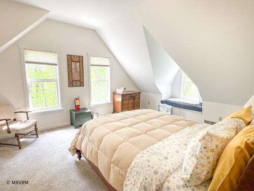 a bedroom with a large bed and two windows at Shady Lane Retreat in Waitsfield