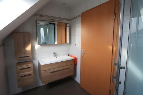 a bathroom with a sink and a mirror at Gîte De L'Oie Blanche in Blodelsheim