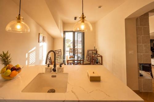 a kitchen with a sink and a dining room at Mamei Boutique Villa in Dobrota
