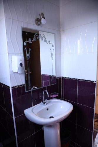 a bathroom with a sink and a mirror at Hotel G in Sūhāj