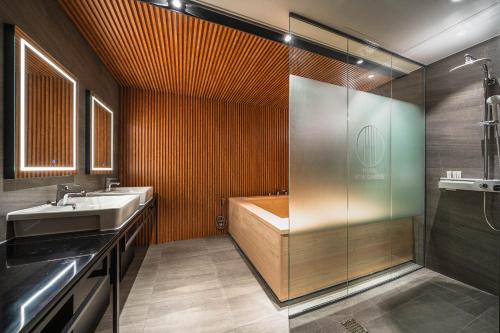 a bathroom with a tub and a sink and a shower at Hotel New Castle Bupyeong in Incheon