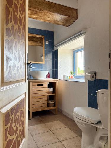 a bathroom with a toilet and a sink at La Marelle in Corberon