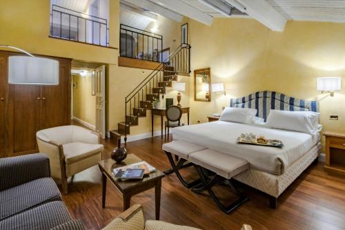 a bedroom with a large bed and a staircase at Sina Maria Luigia in Parma
