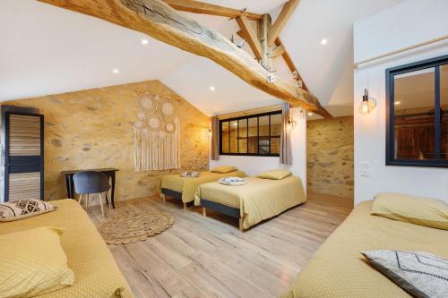 a bedroom with two beds and a fireplace at Gîte La Ferme Du Mesnil in Sevremont