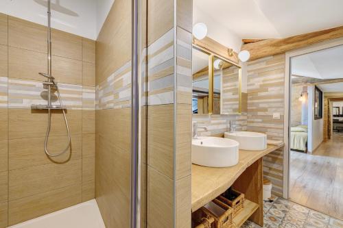a bathroom with two sinks and a shower at Gîte La Ferme Du Mesnil in Sevremont