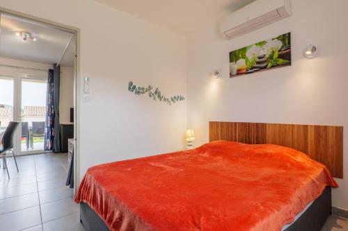 a bedroom with a bed with a red blanket at Résidence Château Saint Martin in Saint-Martin-dʼArdèche