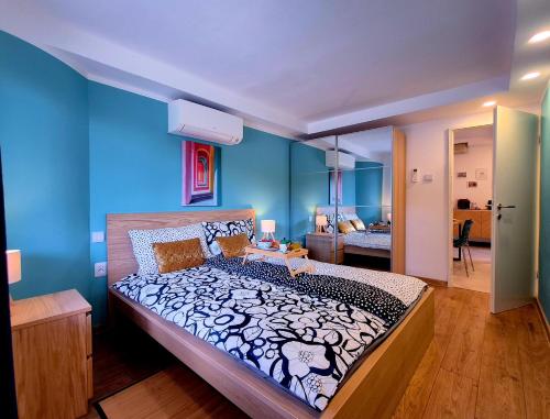 a bedroom with a large bed with blue walls at Casa Morlacca in Matulji
