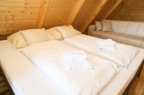 a large white bed in a room with a couch at Cottage Sunshine in Jajce