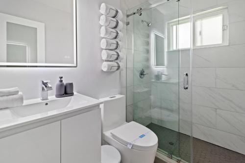 a white bathroom with a toilet and a glass shower at Stylish Dania Beach Stay Beach, Cruise Port FLL Airport in Dania Beach