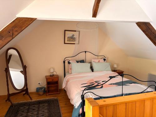 a bedroom with a bed and a large mirror at The Cherries Houehdeu in Naizin