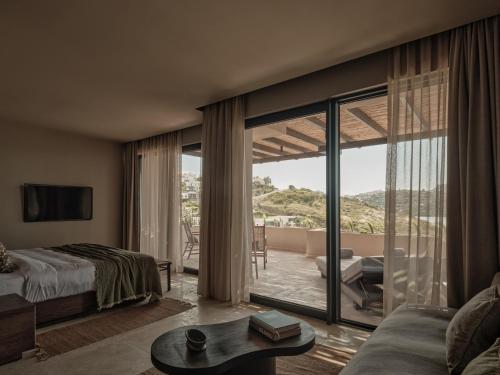 a bedroom with a bed and a living room with a view at OKU Bodrum in Golturkbuku