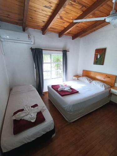 two beds in a room with a window at Amambay Apart &Suites in Eldorado