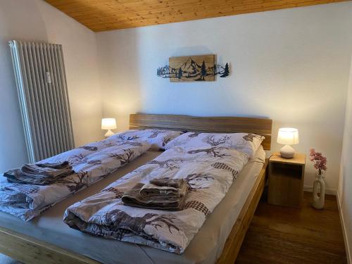 a bed in a room with two lamps at Haus Anemona in Savognin