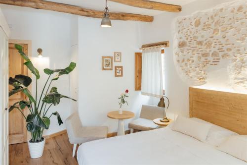 a bedroom with a bed and a table and chairs at Locanda delle rose in Roccavaldina