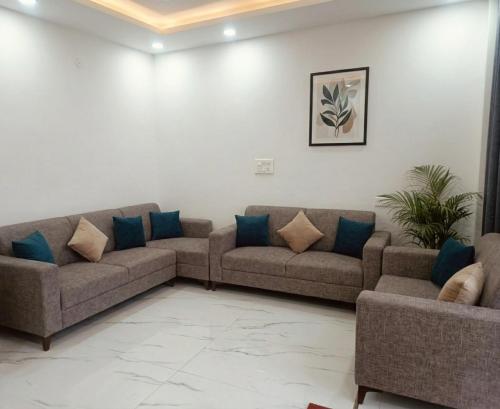 a living room with two couches and blue pillows at Hotel Brothers Kalka Highway in Panchkula