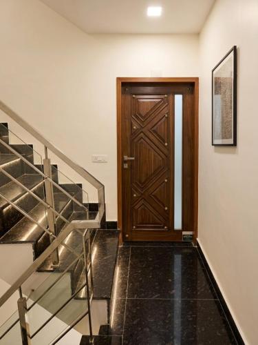 a wooden door in a hallway with stairs at Hotel Brothers Kalka Highway in Panchkula