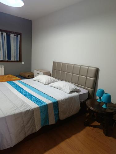 a bedroom with a large bed and a table at Flamant apart in Aguçadoura
