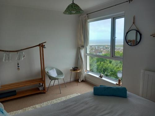 a bedroom with a bed and a large window at Lundy Views in Northam