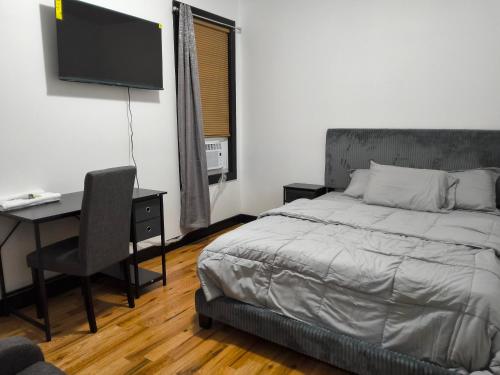 a bedroom with a bed and a desk and a television at Log Comfort 3 in Irvington