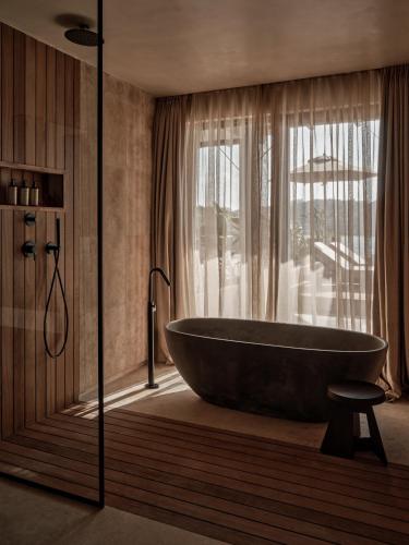 a bathroom with a large tub and a window at OKU Bodrum in Golturkbuku