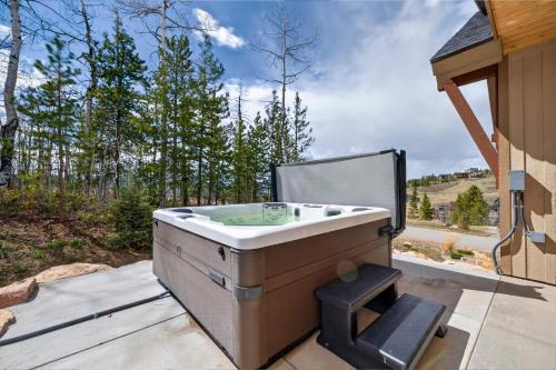 a bath tub sitting on a patio next to a house at 238 Night Hawk Home in Granby
