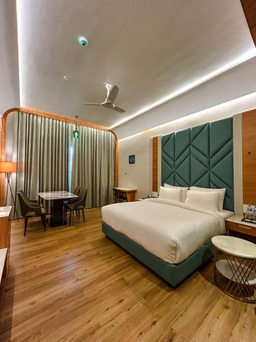 a hotel room with a bed and a table and chairs at Hotel Imperial Blu in Similigurha