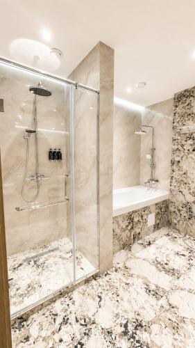 a bathroom with a shower and a glass shower stall at NOMAD Luxe Hotel in Zharkent