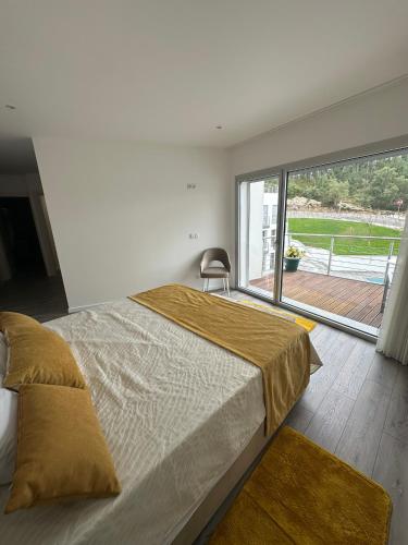 a bedroom with a large bed and a large window at Apartamento As T3 Pombal in Pombal