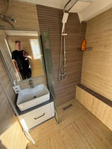 a man taking a picture of himself in a bathroom mirror at Villa Adushi in Prizren