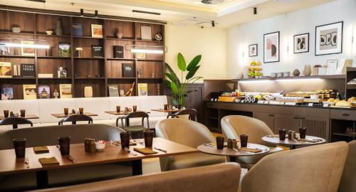 a restaurant with tables and chairs and a counter at Honest Budapest by chic&basic in Budapest