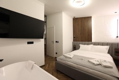 a bedroom with a large white bed with towels on it at Montéa Villa in Brezovica
