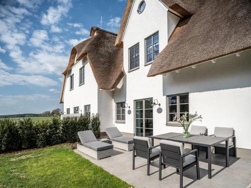 a patio with a table and chairs in front of a house at Reetidyll am Haff in Stolpe auf Usedom