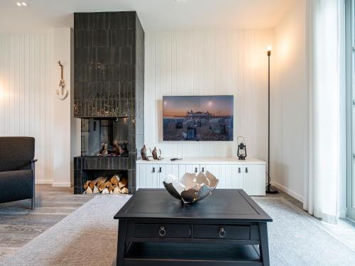 a living room with a black coffee table and a fireplace at Reetidyll am Haff in Stolpe auf Usedom