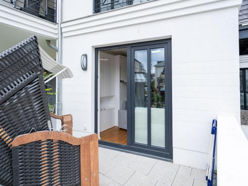 a glass door on a white house with a bench at Quartier 7, App 06 in Ahlbeck