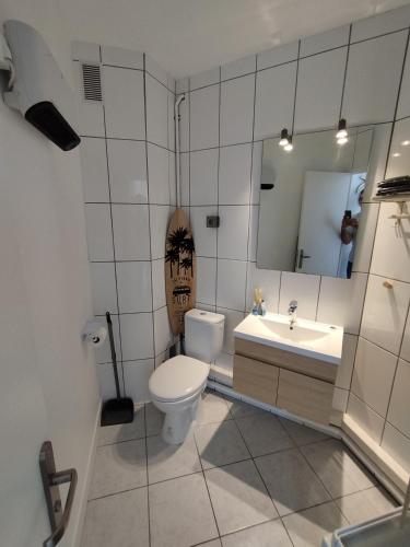 a bathroom with a toilet and a sink and a mirror at Studio vue mer & accès direct à la plage in Le Barcarès