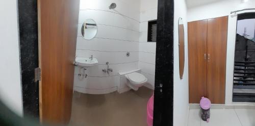a bathroom with a toilet and a sink at Hotel Madhav Shankar in Rajkot