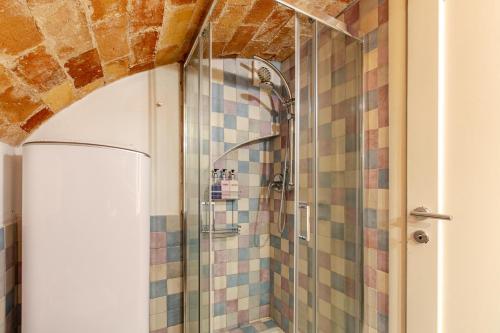 a bathroom with a shower with tiled walls at Loft 34 in Tarquinia