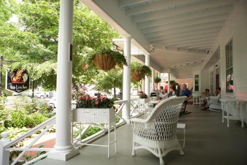 a porch with chairs and people sitting at tables at The Red Lion Inn in Stockbridge