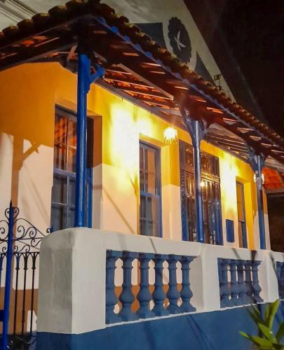 a house with a blue and white balcony at Refúgio Casarão in Passa Quatro